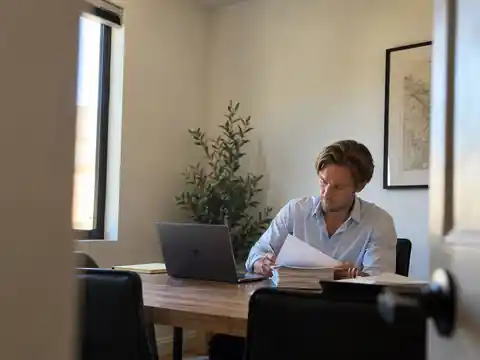 Illustrative office scene representing attorney Trenton Nield reviewing estate planning and trust funding documents beside a laptop